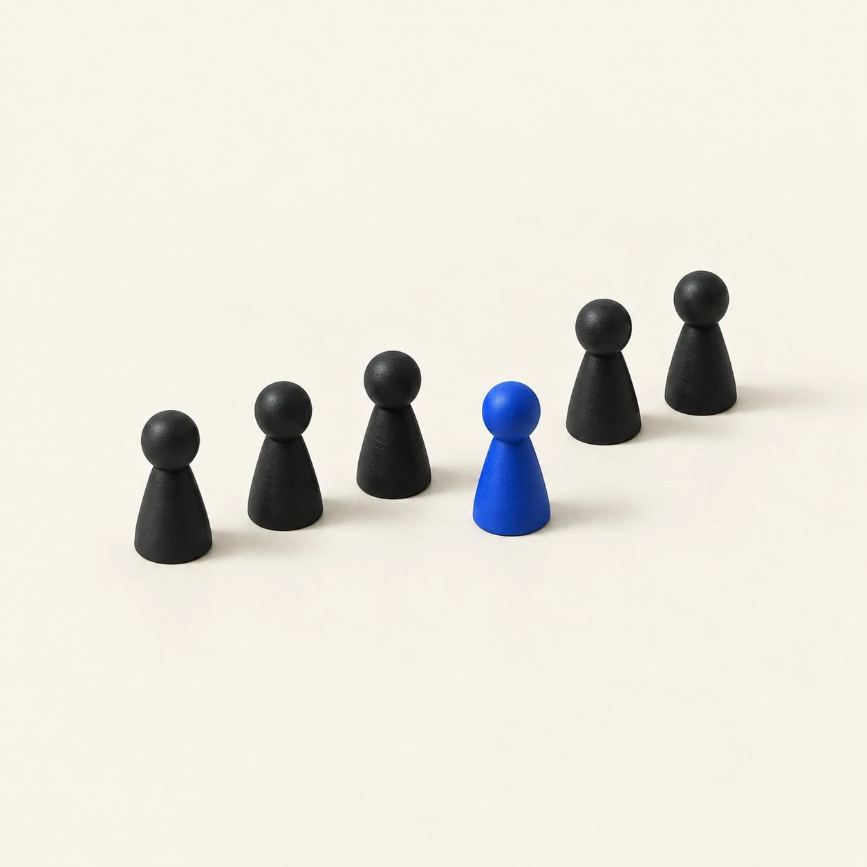 Illustration: Sechs Spielfiguren in einer Reihe, eine davon blau.